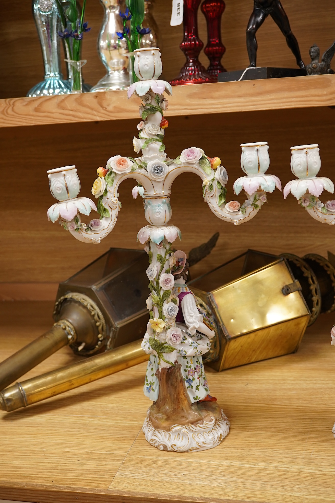 A pair of Volkstedt porcelain figural three branch candelabra with floral encrusted decoration, 51cm high